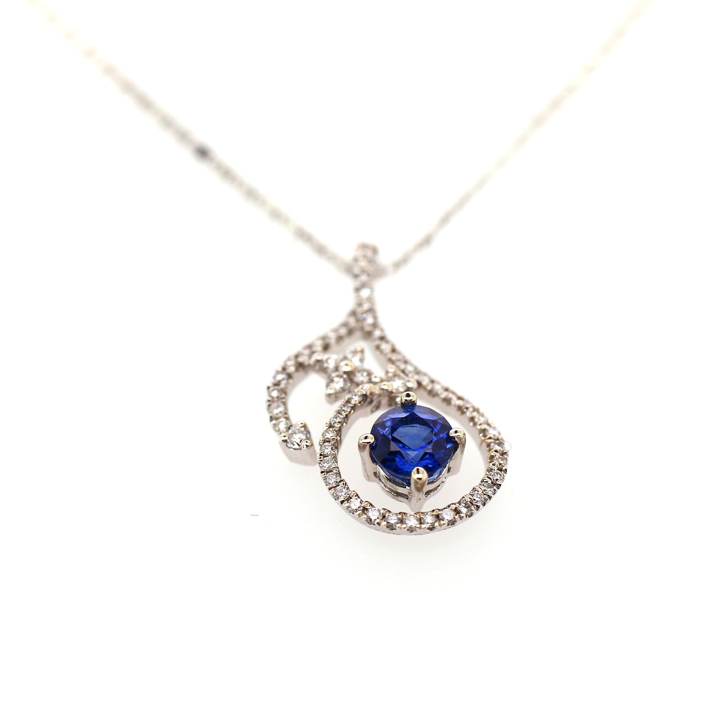 Vivid Blue Sapphire has been Elegantly set with Natural Diamonds to create this 18kt White Gold Pendant.