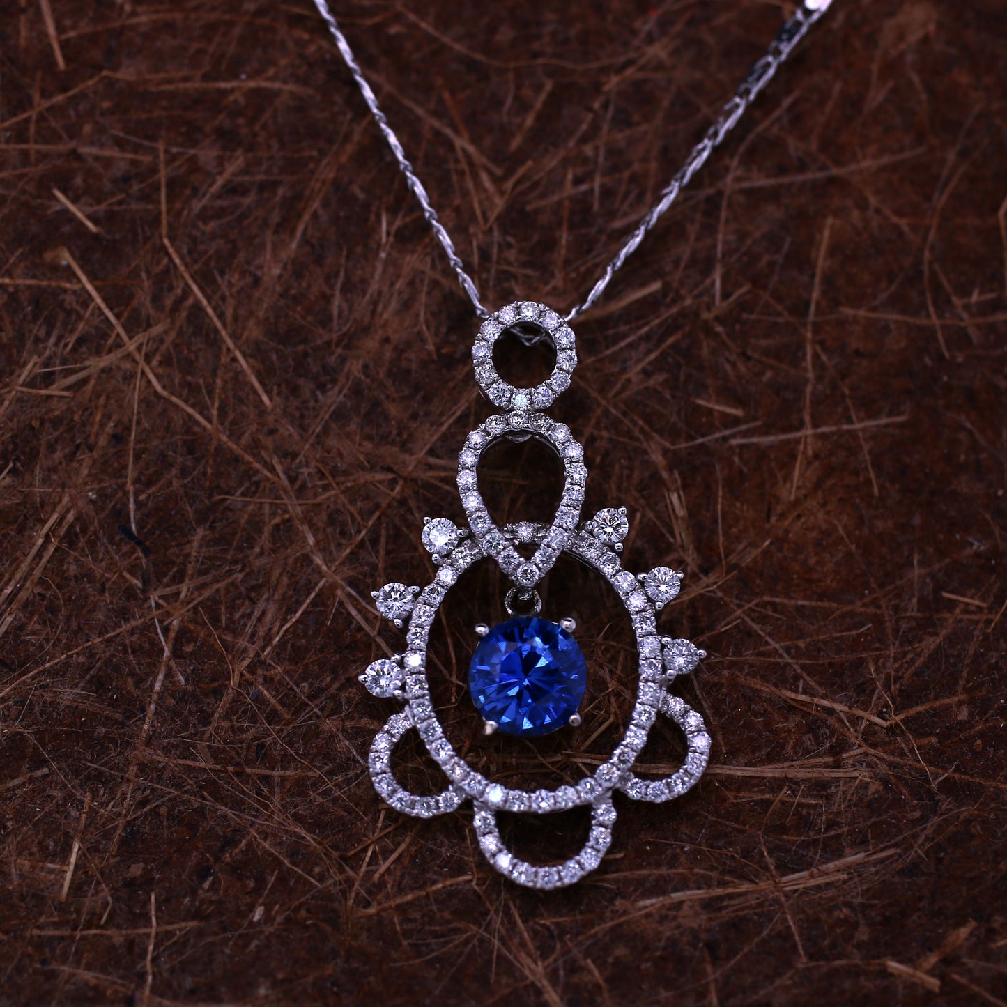 Natural Blue Sapphire pendant in 18K White Gold. It has a Round Faceted cut Sapphire studded with halo of diamonds that completes your look with a decent touch.