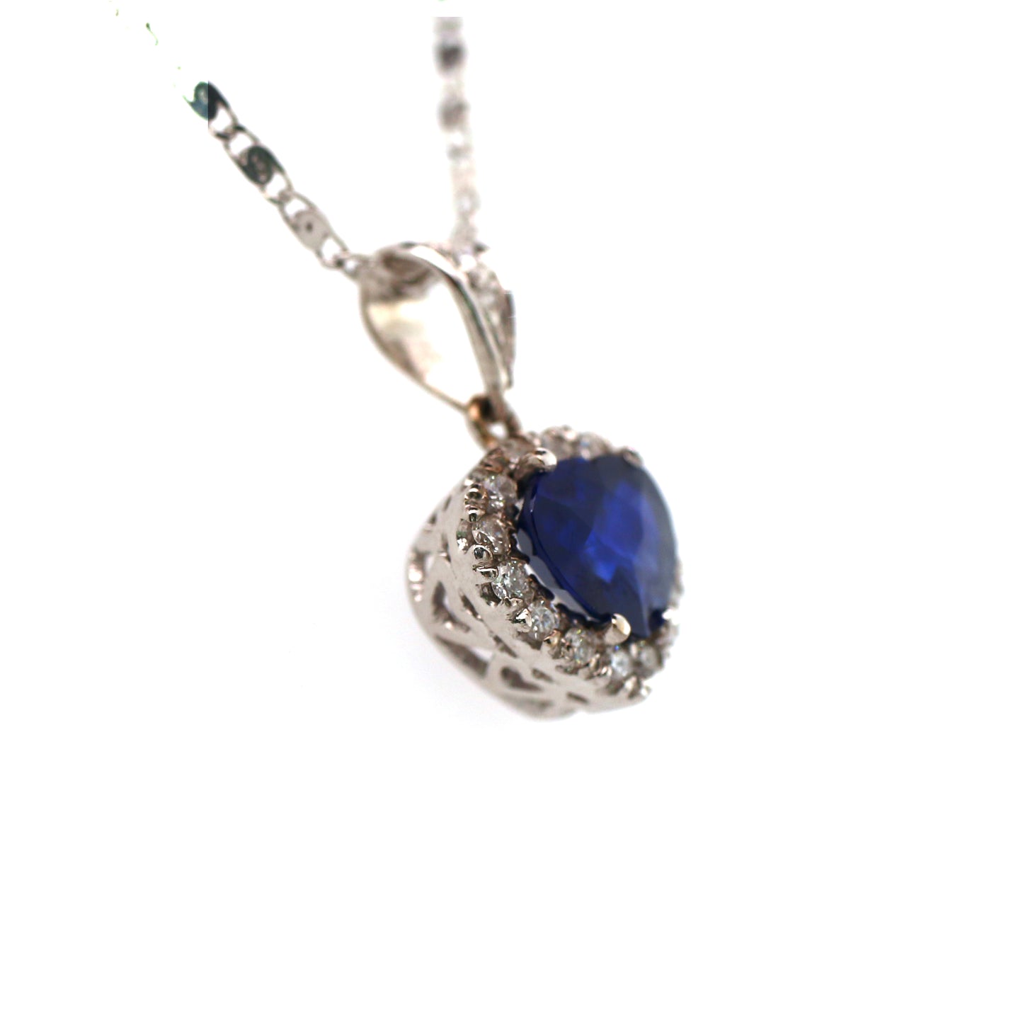 A unique 18K White Gold Pendant with a excellent natural Heart cut Blue Sapphire in the Center. A Heart design Diamond halo enhances the vivid blue of the Precious Stone.