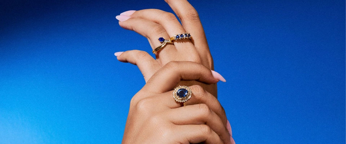 Hands wearing sapphire jewellery against cobalt blue