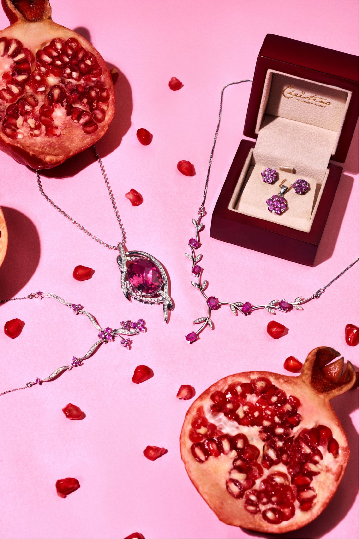 Pendant, necklace and ring box among pomegranates on pink