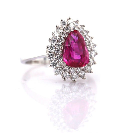 In this stunning estate jewel, a beautifully modeled pear shape Ceylon Ruby with Halo Diamonds