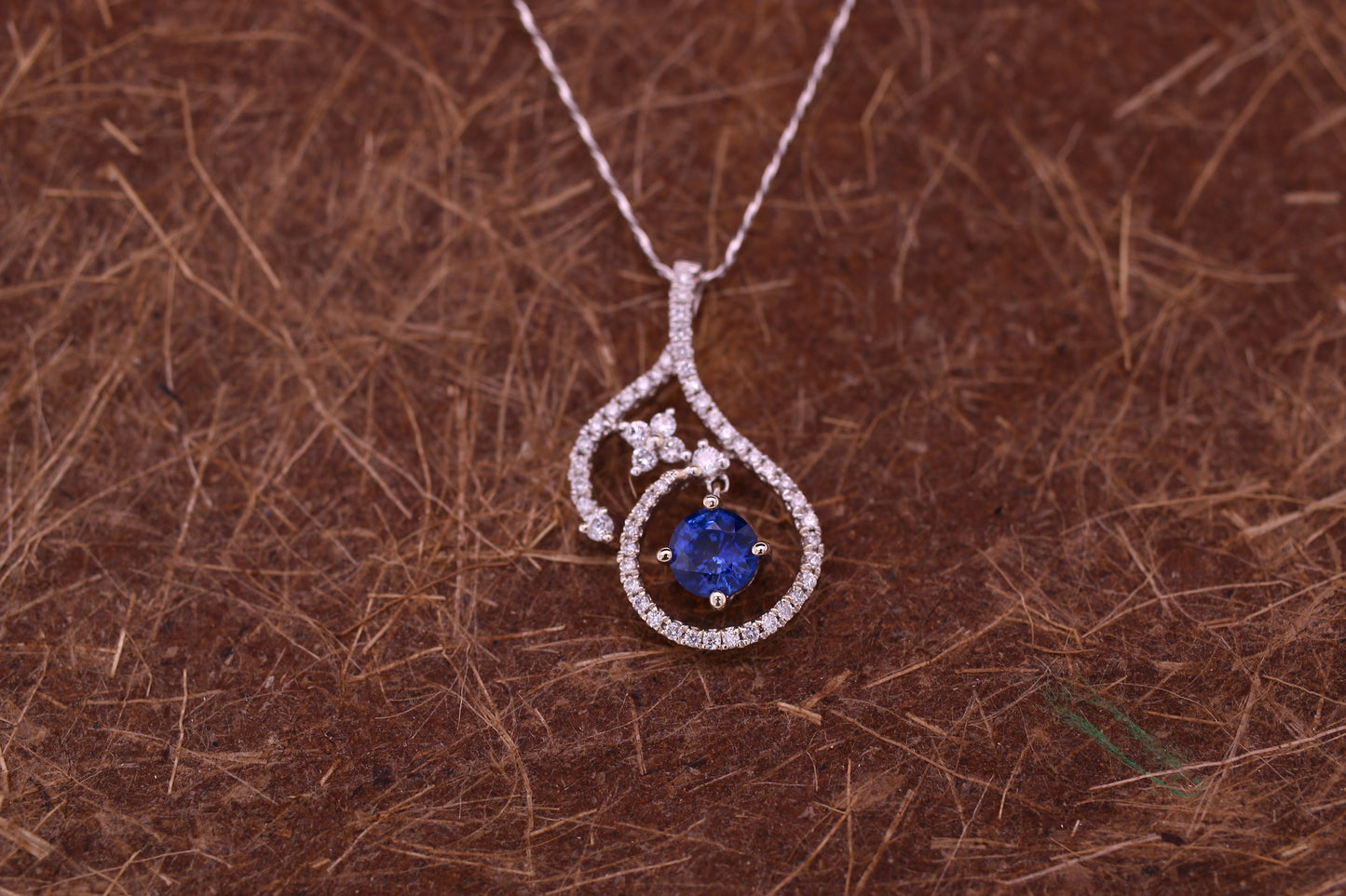 Vivid Blue Sapphire has been Elegantly set with Natural Diamonds to create this 18kt White Gold Pendant.