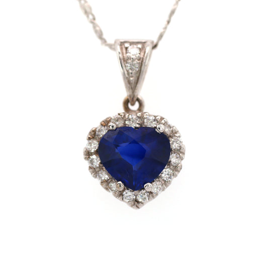 A unique 18K White Gold Pendant with a excellent natural Heart cut Blue Sapphire in the Center. A Heart design Diamond halo enhances the vivid blue of the Precious Stone.