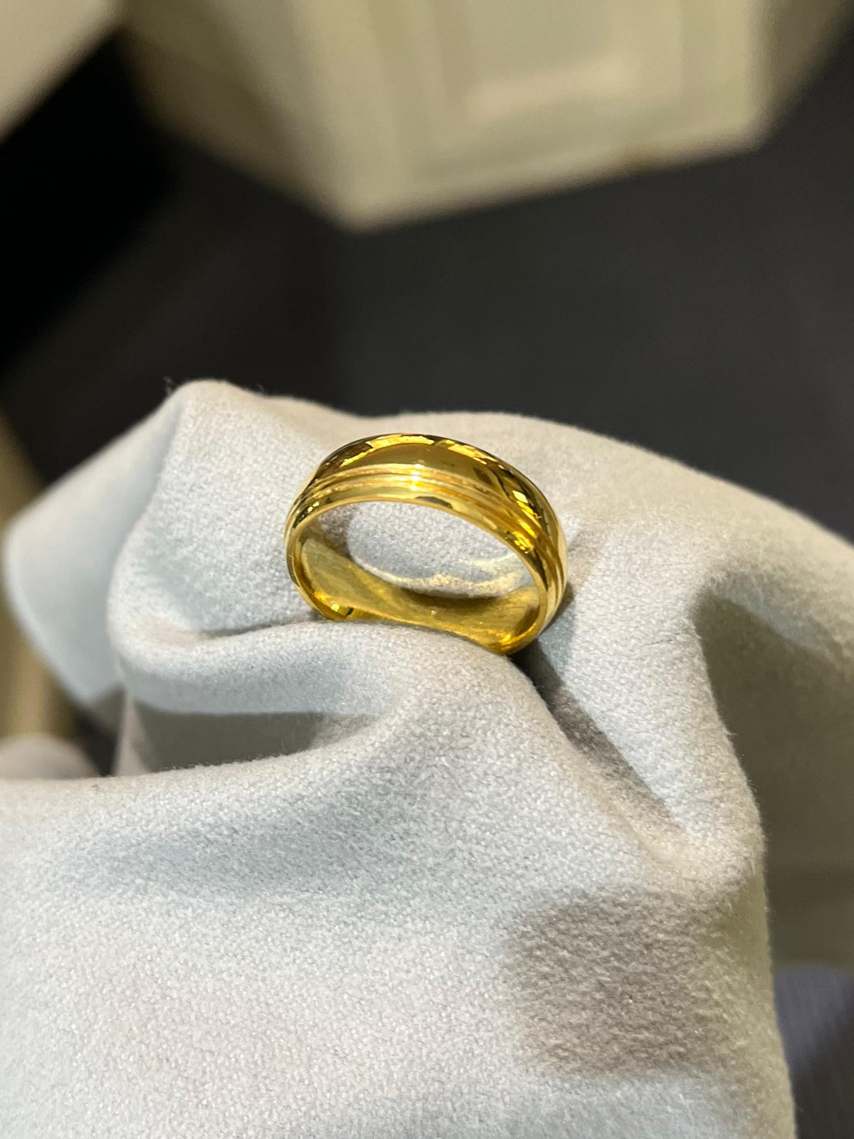 A plain gold band resting on a white cloth